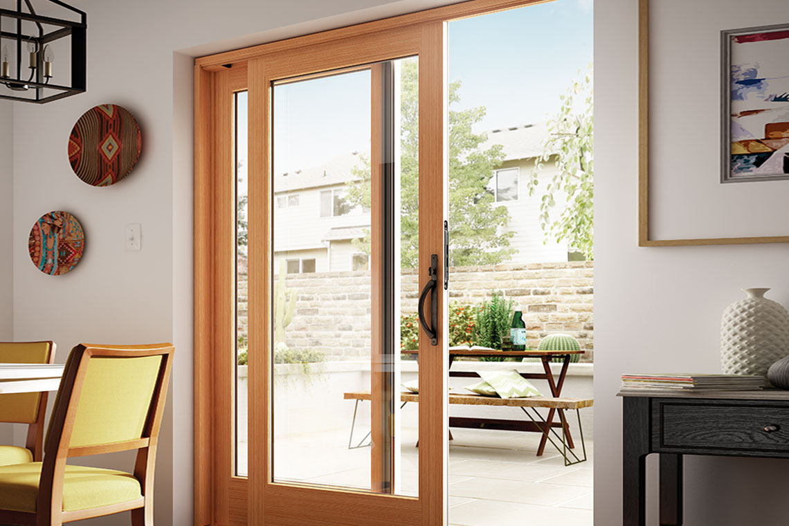 Warm wood-framed glazed doors opening to an outdoor dining space