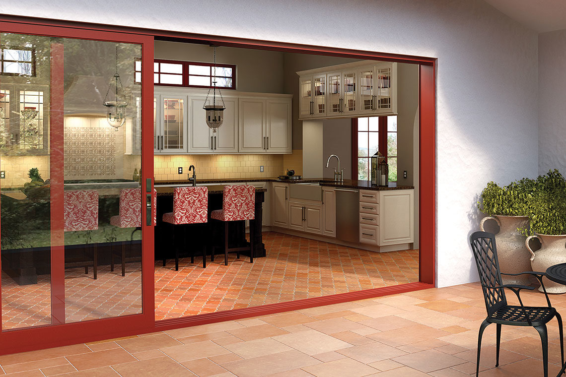 Red-framed folding doors opening a kitchen to a patio